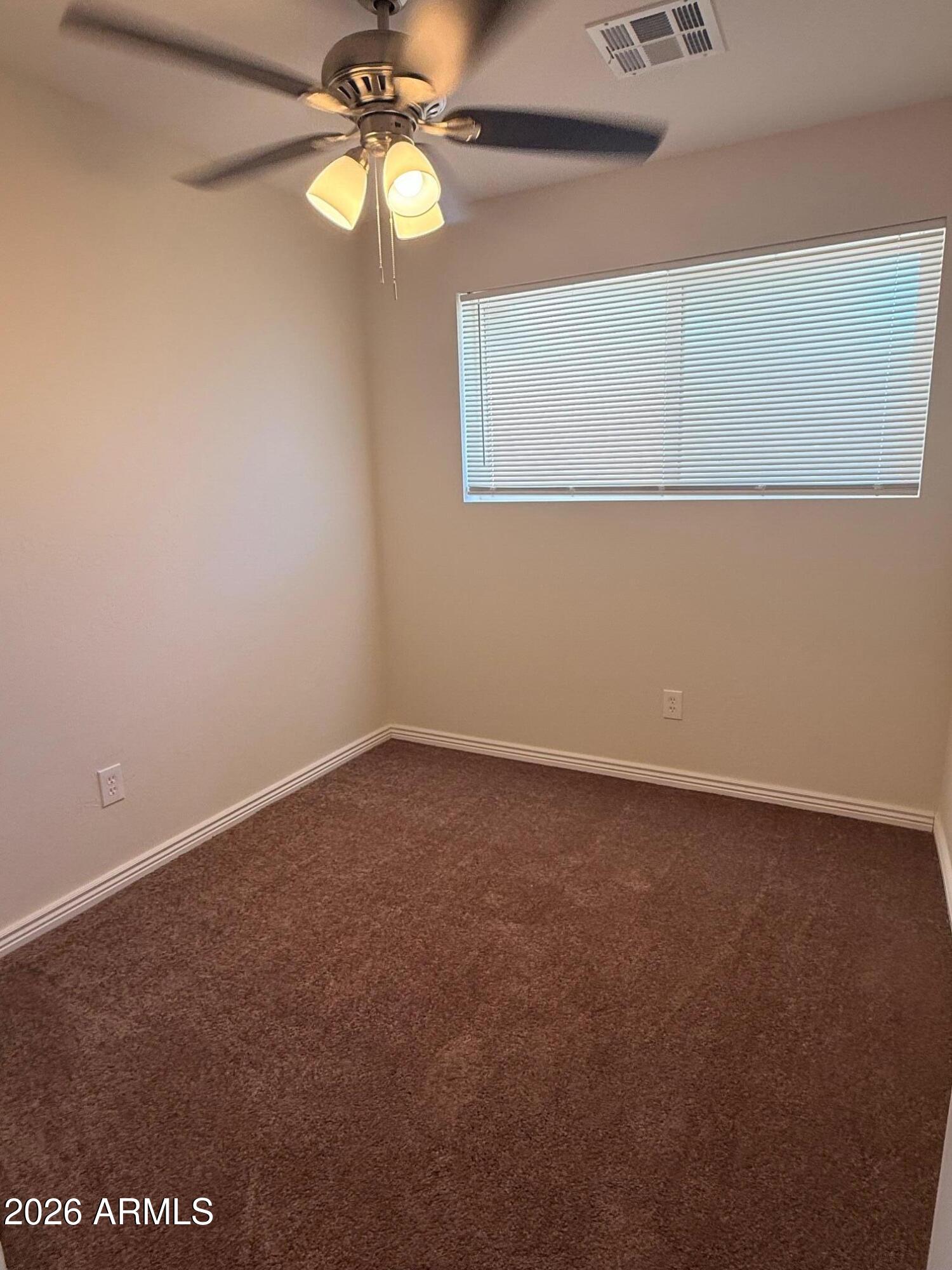 135 Rex Avenue Apache Junction, AZ 85120 - Photo 11 of 27 an empty room with a window and a fan