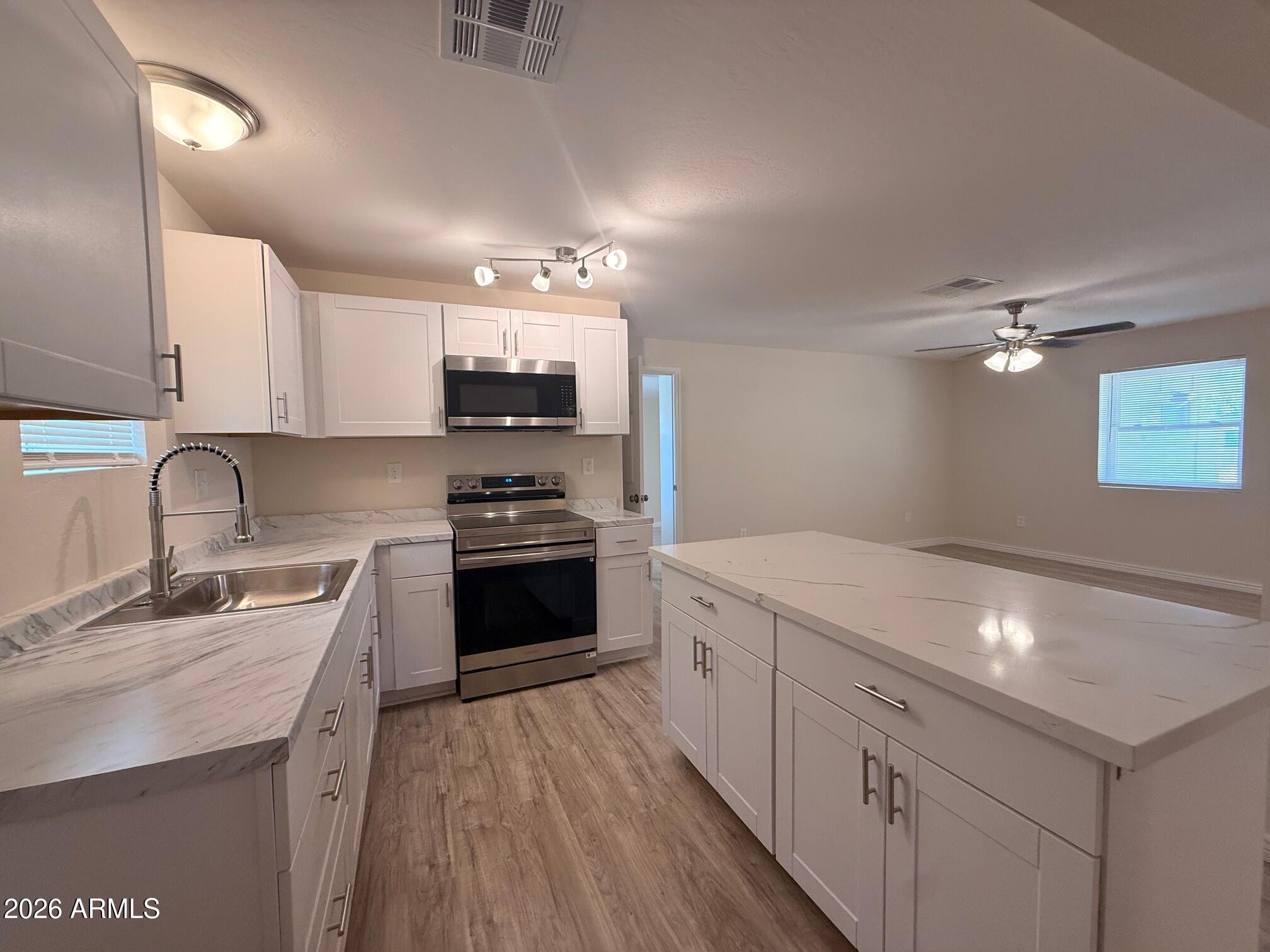 135 Rex Avenue Apache Junction, AZ 85120 - Photo 21 of 27 a kitchen with kitchen island granite countertop a sink stainless steel appliances and cabinets