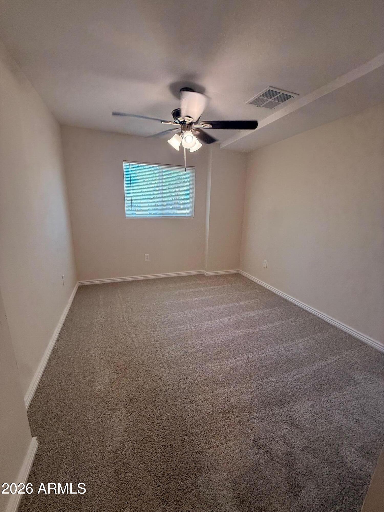 135 Rex Avenue Apache Junction, AZ 85120 - Photo 24 of 27 a view of a room with a ceiling fan and carpet