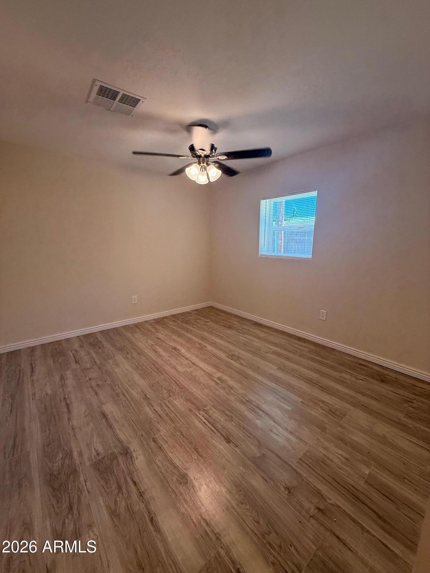 135 Rex Avenue Apache Junction, AZ 85120 - Photo 26 of 27 a view of a room with wooden floor and a ceiling fan