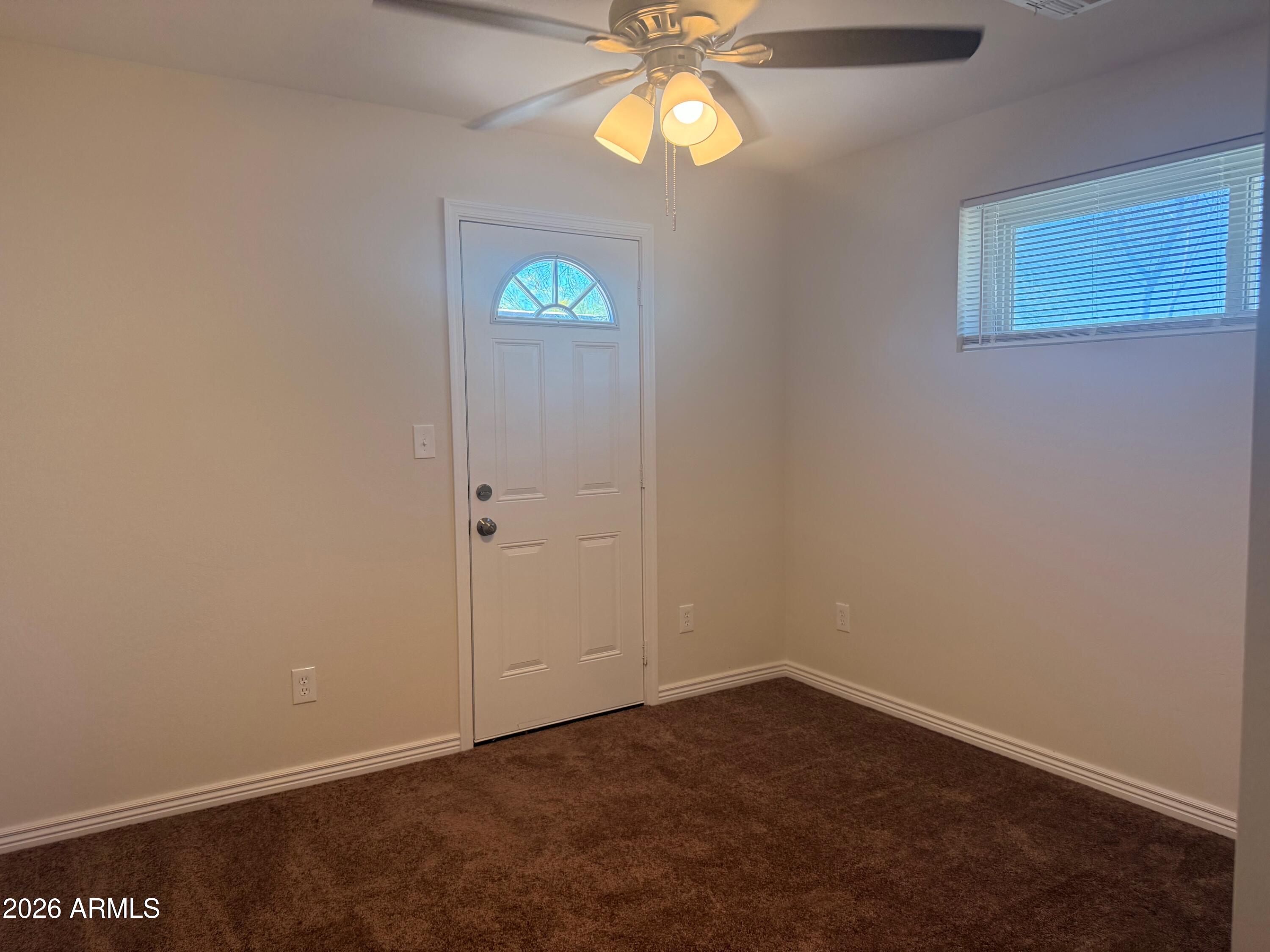 135 Rex Avenue Apache Junction, AZ 85120 - Photo 4 of 27 an empty room with windows and ceiling fan