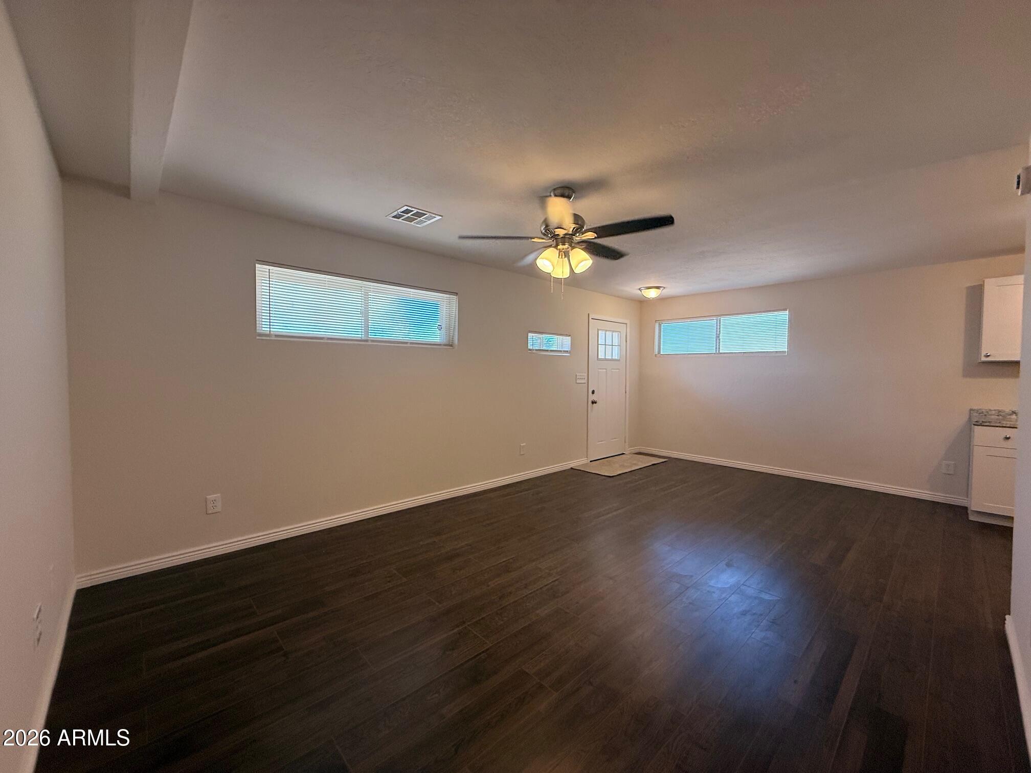 135 Rex Avenue Apache Junction, AZ 85120 - Photo 5 of 27 a view of an empty room with wooden floor and a window