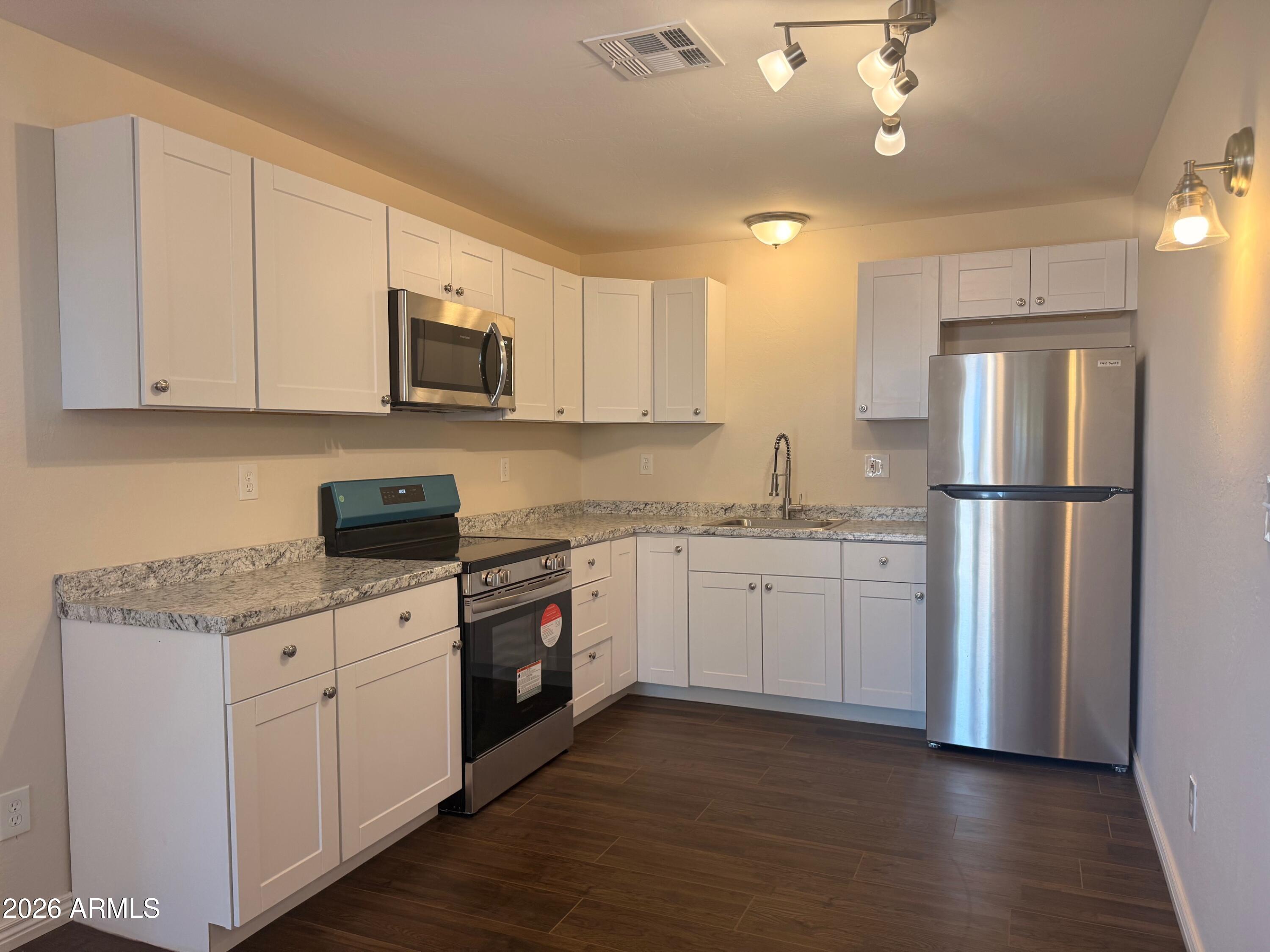135 Rex Avenue Apache Junction, AZ 85120 - Photo 8 of 27 a kitchen with sink cabinets and stainless steel appliances