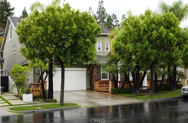 a front view of a house with a garden and tree