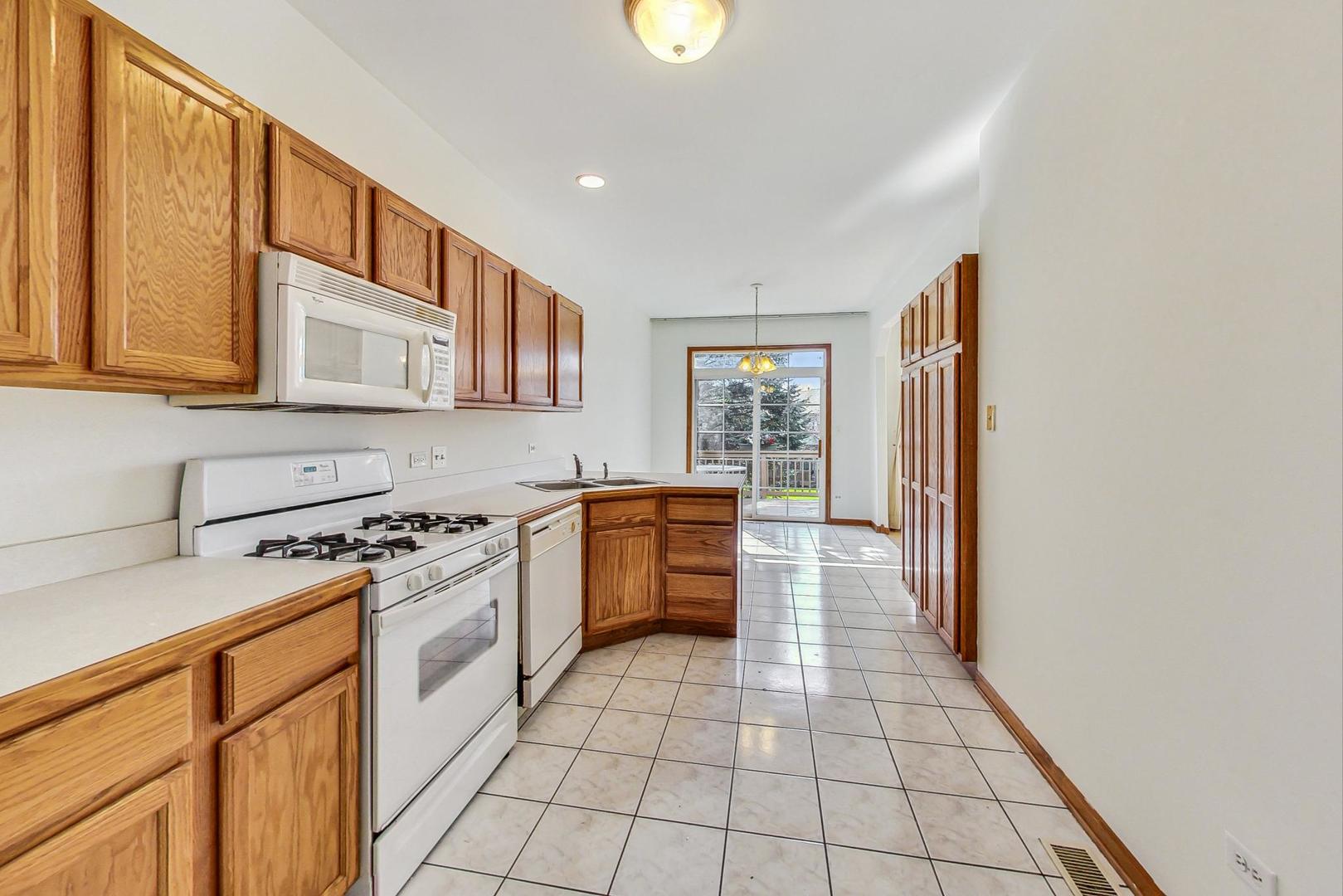 565 Goodwin Drive Bolingbrook, IL 60440 - Photo 14 of 44 a kitchen with stainless steel appliances granite countertop a stove a sink and a refrigerator