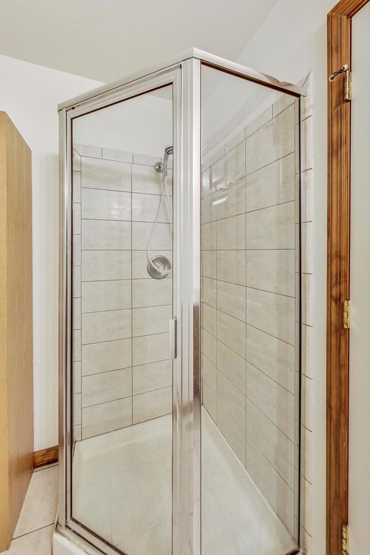 565 Goodwin Drive Bolingbrook, IL 60440 - Photo 25 of 44 a bathroom with a glass shower door