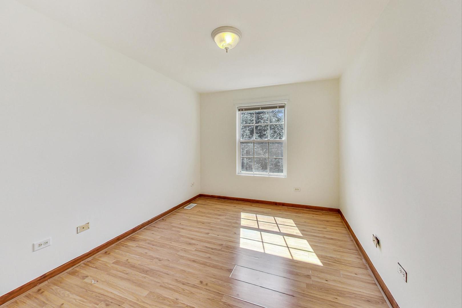 565 Goodwin Drive Bolingbrook, IL 60440 - Photo 26 of 44 an empty room with wooden floor and windows
