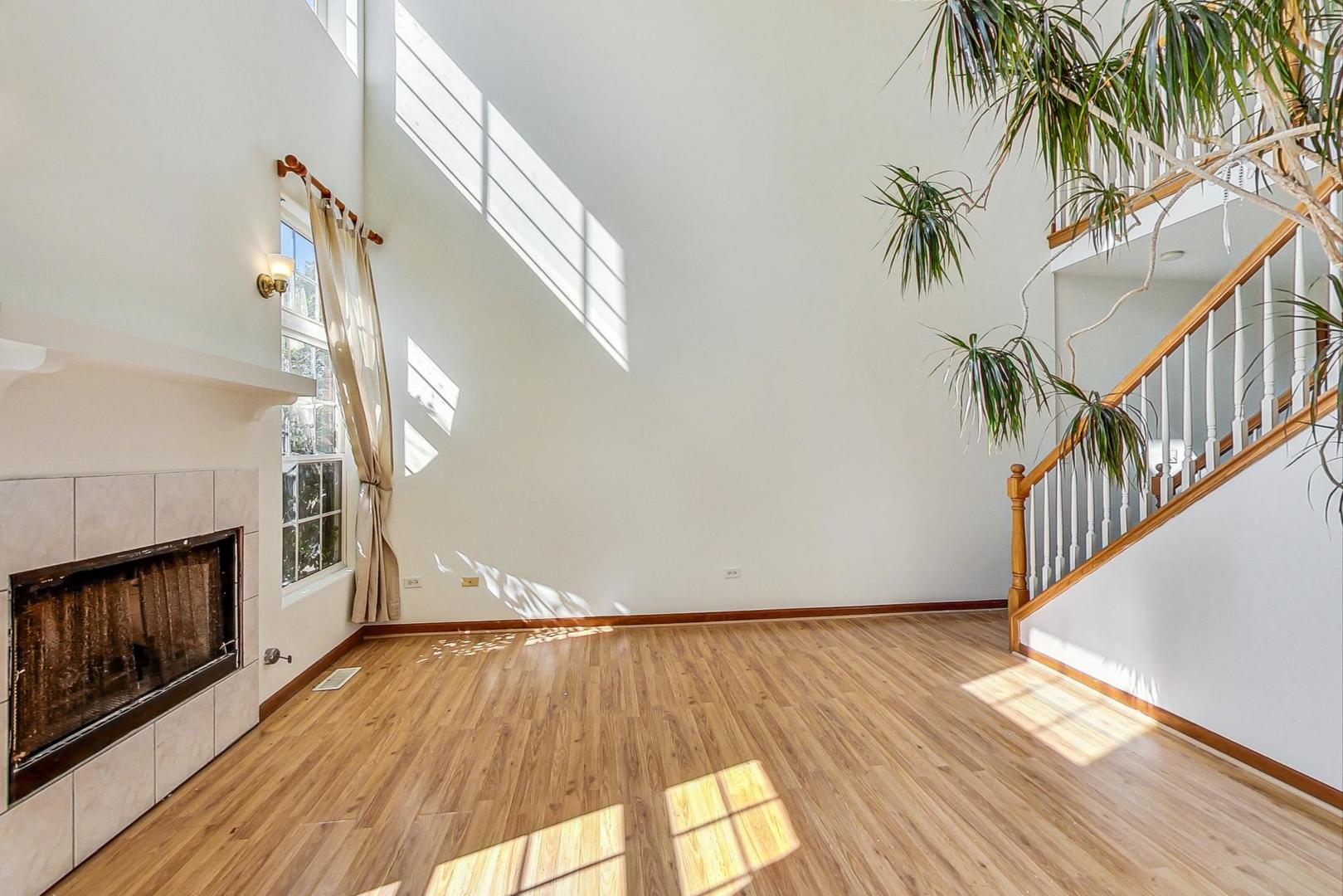 565 Goodwin Drive Bolingbrook, IL 60440 - Photo 7 of 44 a view of a hallway with wooden floor and a fireplace