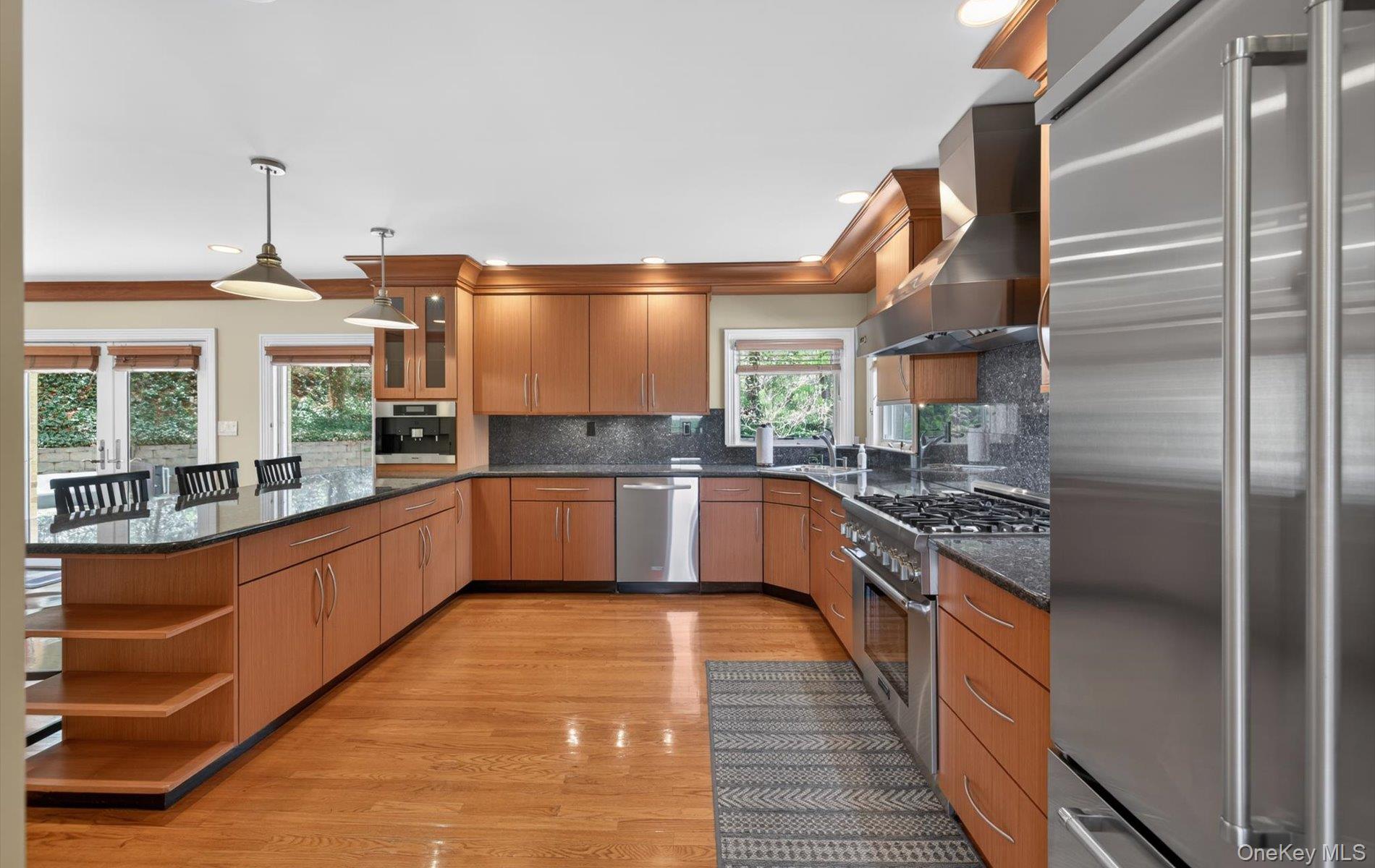 16 East Slope Road Bayville, NY 11709 - Photo 10 of 48 Spacious kitchen featuring a large island with seating, wood-finish flooring, stainless steel appliances, ample cabinetry, and granite countertops