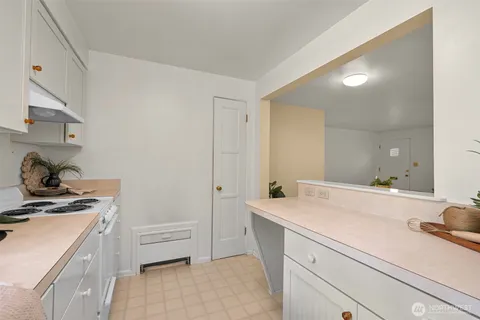 a view of washer and dryer with kitchen in the background