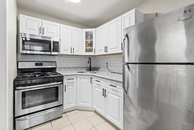 a kitchen with cabinets stainless steel appliances and a refrigerator