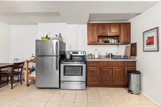 a kitchen with stainless steel appliances granite countertop a refrigerator and a stove top oven