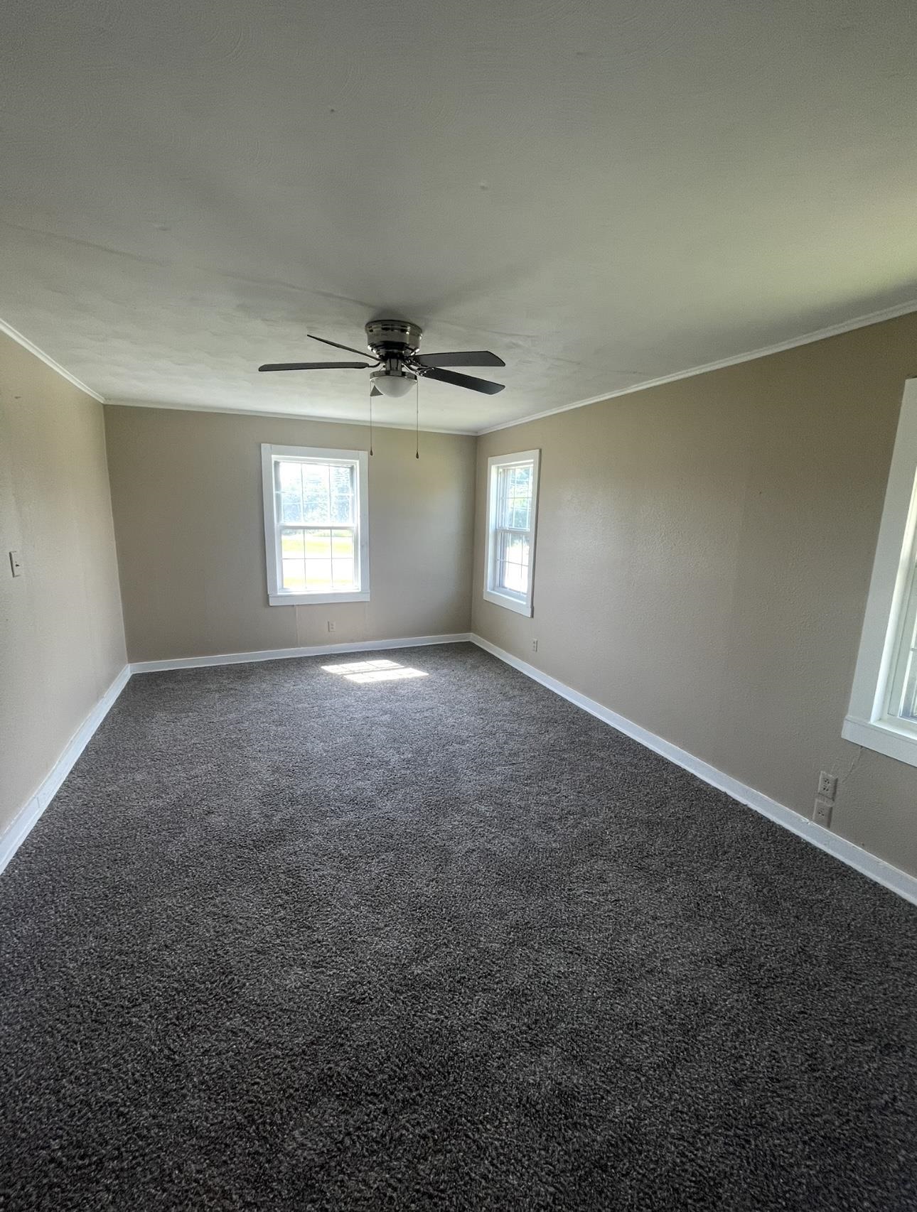 183 North Main Street Ripley, TN 38063 - Photo 8 of 8 an empty room with windows and chandelier fan