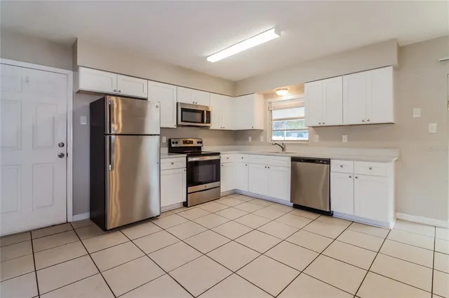 a kitchen with a sink a refrigerator and cabinets