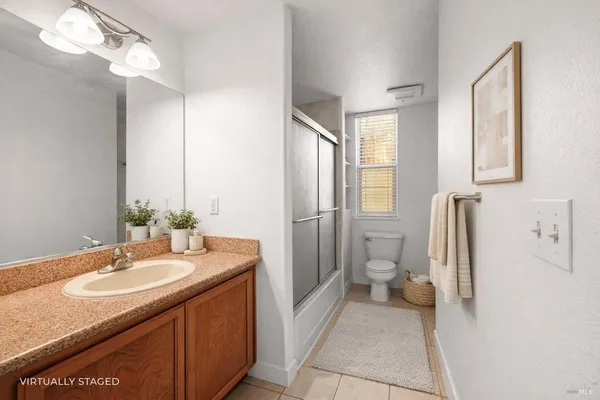 a bathroom with a granite countertop sink a toilet and a mirror