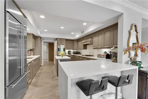 a kitchen with a sink a refrigerator and chairs