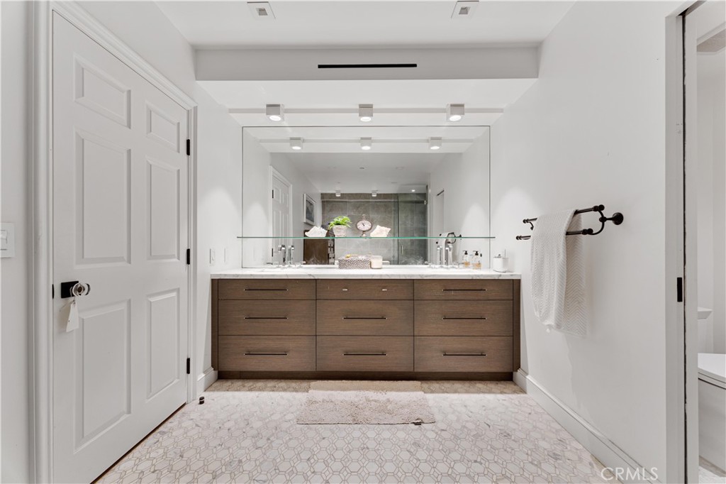 277 South Spalding Drive, Unit 201 Beverly Hills, CA 90212 - Photo 20 of 31 a bathroom with a double vanity sink mirror and