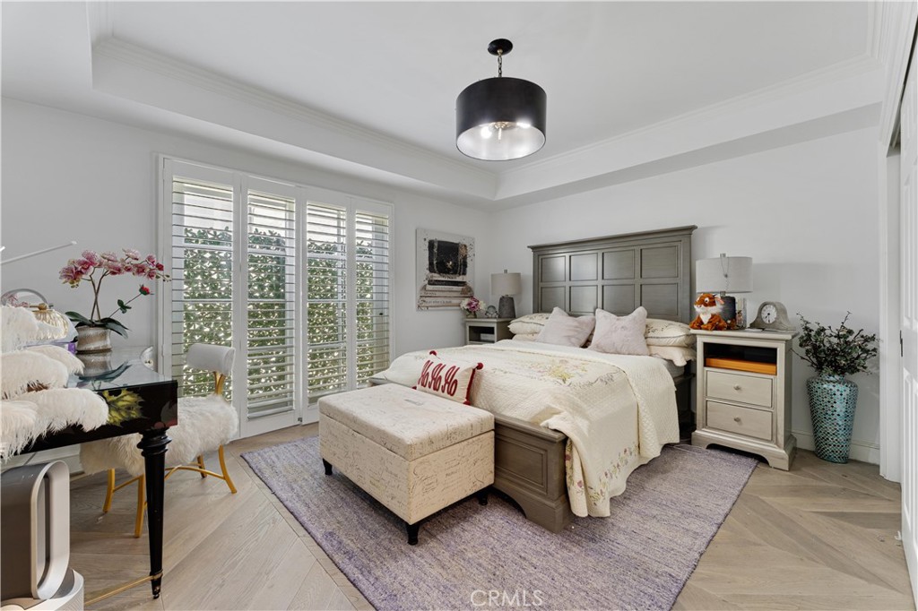 277 South Spalding Drive, Unit 201 Beverly Hills, CA 90212 - Photo 22 of 31 a spacious bedroom with a bed and a chandelier