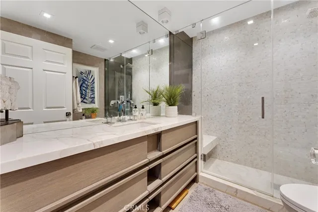 a bathroom with a double vanity sink toilet mirror and bathtub