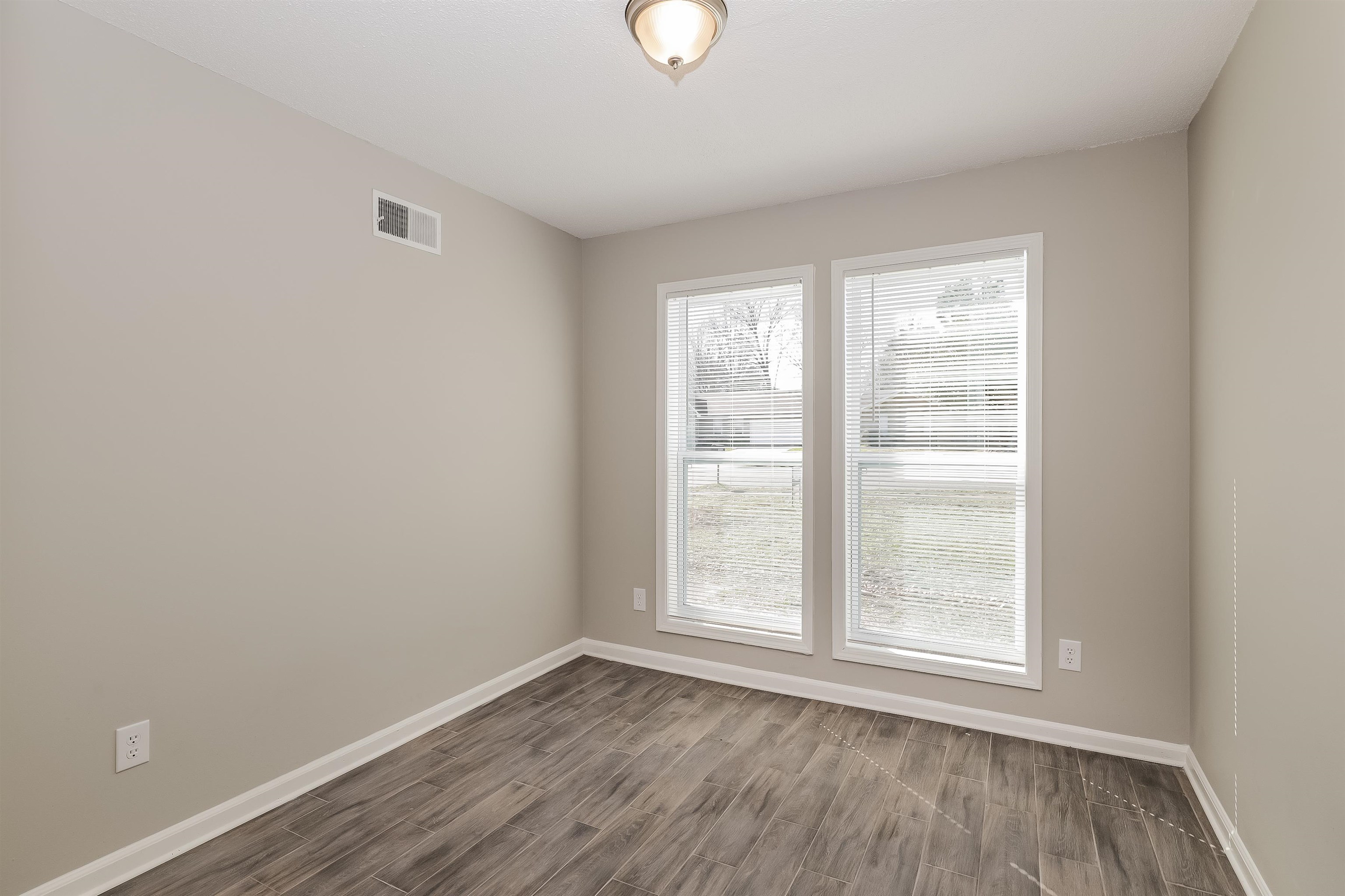 3054 Ridgeway Road Memphis, TN 38115 - Photo 12 of 17 an empty room with wooden floor and windows