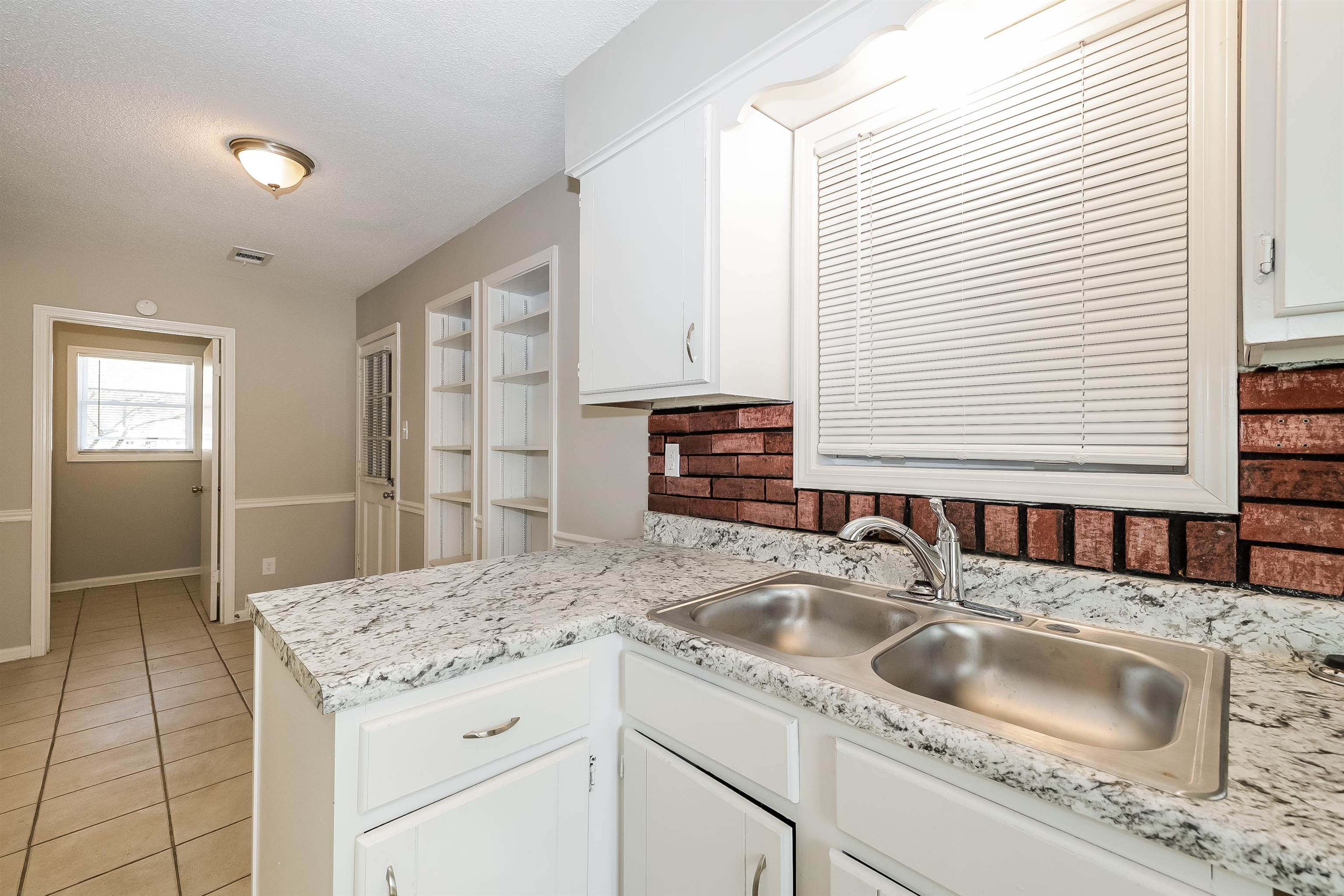 3054 Ridgeway Road Memphis, TN 38115 - Photo 8 of 17 a kitchen with granite countertop a sink and a window