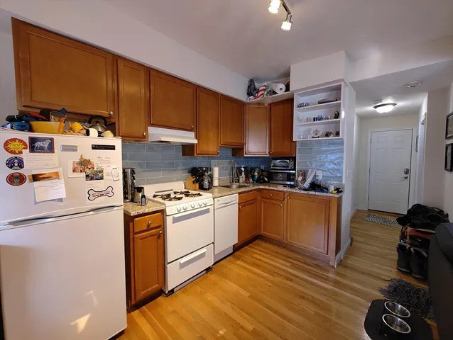 a kitchen with stainless steel appliances granite countertop a refrigerator and a stove top oven