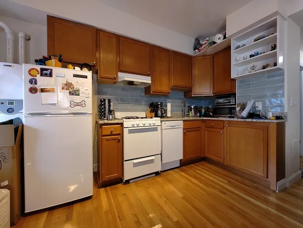 a kitchen with a refrigerator a stove a sink dishwasher and wooden cabinets