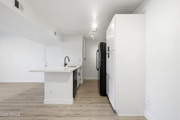 a view of a kitchen from the hallway with a sink