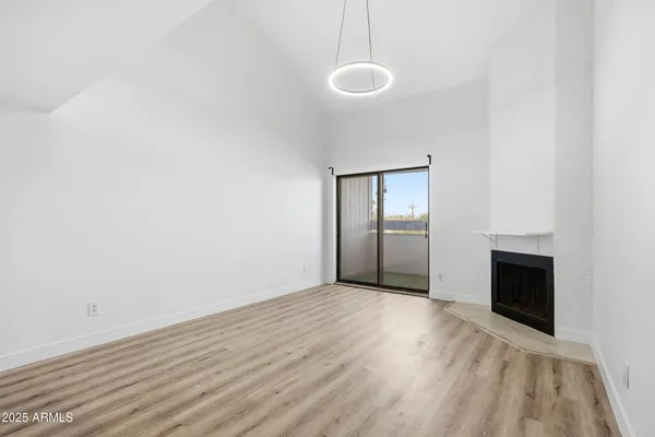a view of an empty room with a fireplace and a window