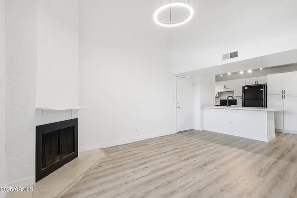 a view of empty room with wooden floor and fireplace