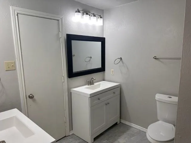 a bathroom with a toilet sink and mirror