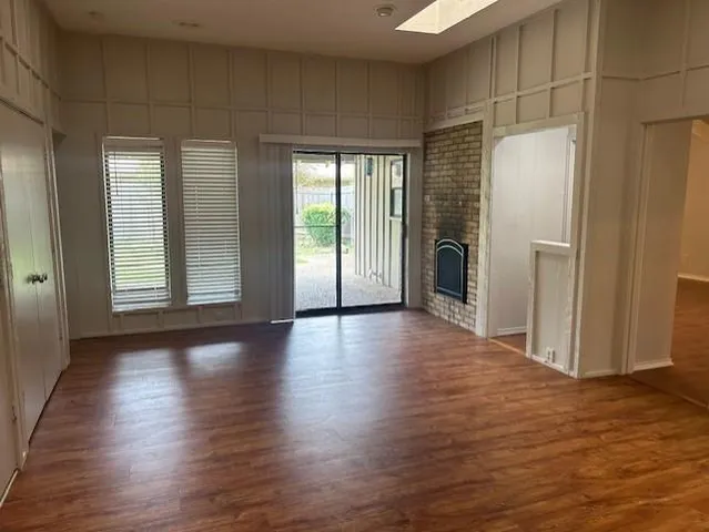 a view of a kitchen with wooden floor and a refrigerator