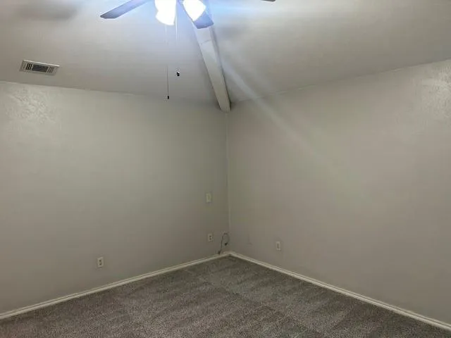 an empty room with a ceiling fan and window
