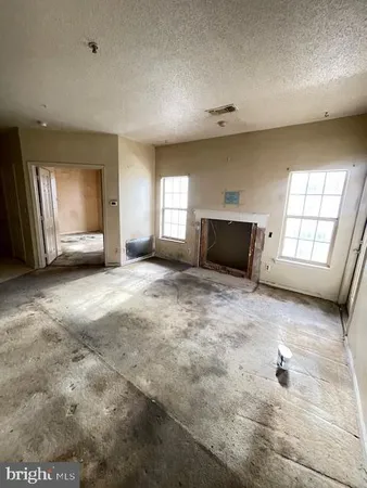en empty room with a fireplace and windows