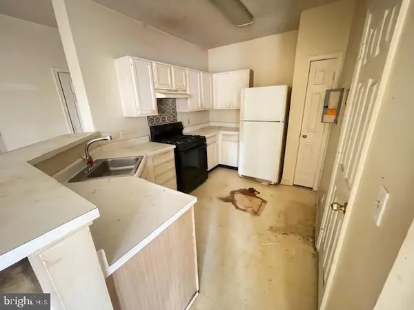 a kitchen with a refrigerator a stove a sink dishwasher and white cabinets with wooden floor