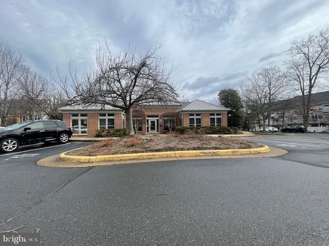 1716 Lake Shore Crest Drive, Unit 22 Reston, VA 20190 - Photo 27 of 28 a front view of a house with a yard and a car parked on road