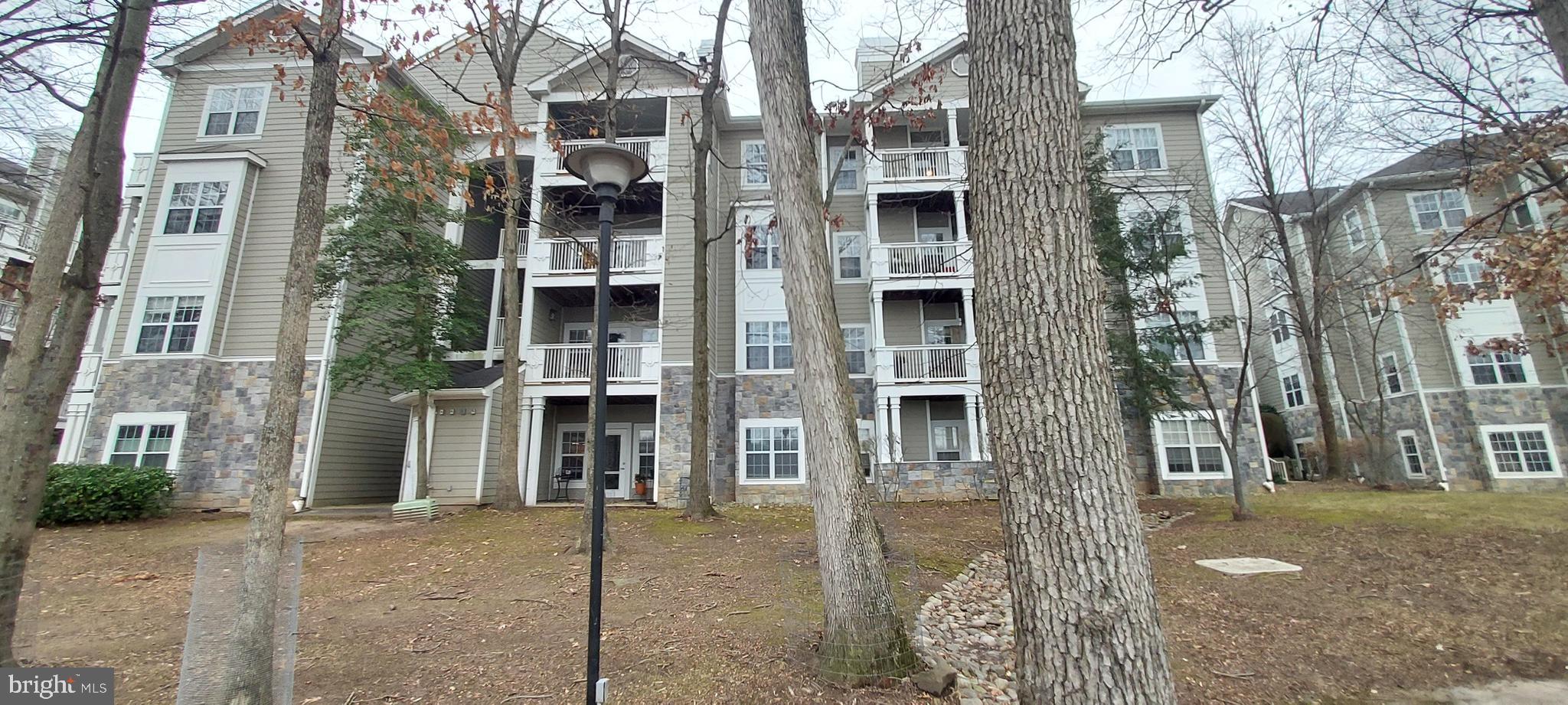 1716 Lake Shore Crest Drive, Unit 22 Reston, VA 20190 - Photo 8 of 28 a view of a house with a door and covered trees