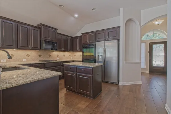 a kitchen with granite countertop a sink stove and cabinets