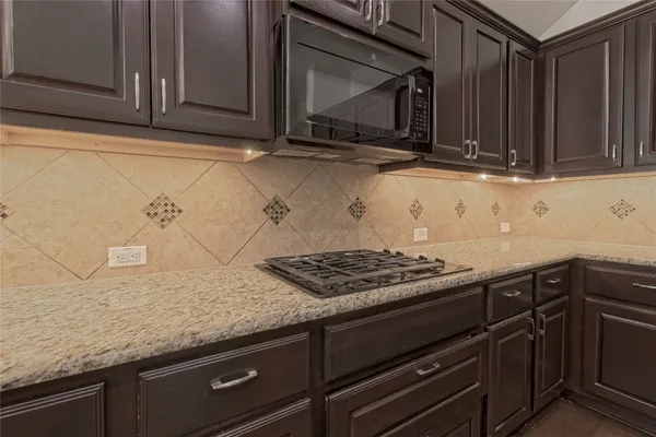 a kitchen with stainless steel appliances granite countertop a refrigerator a sink and wooden cabinets