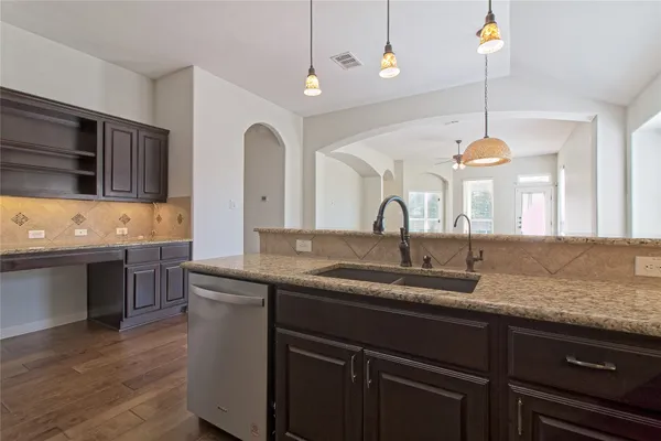 a kitchen with granite countertop cabinets stove and microwave