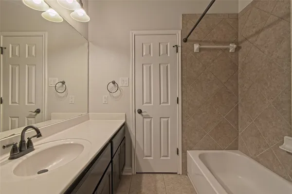 a bathroom with a tub sink and mirror