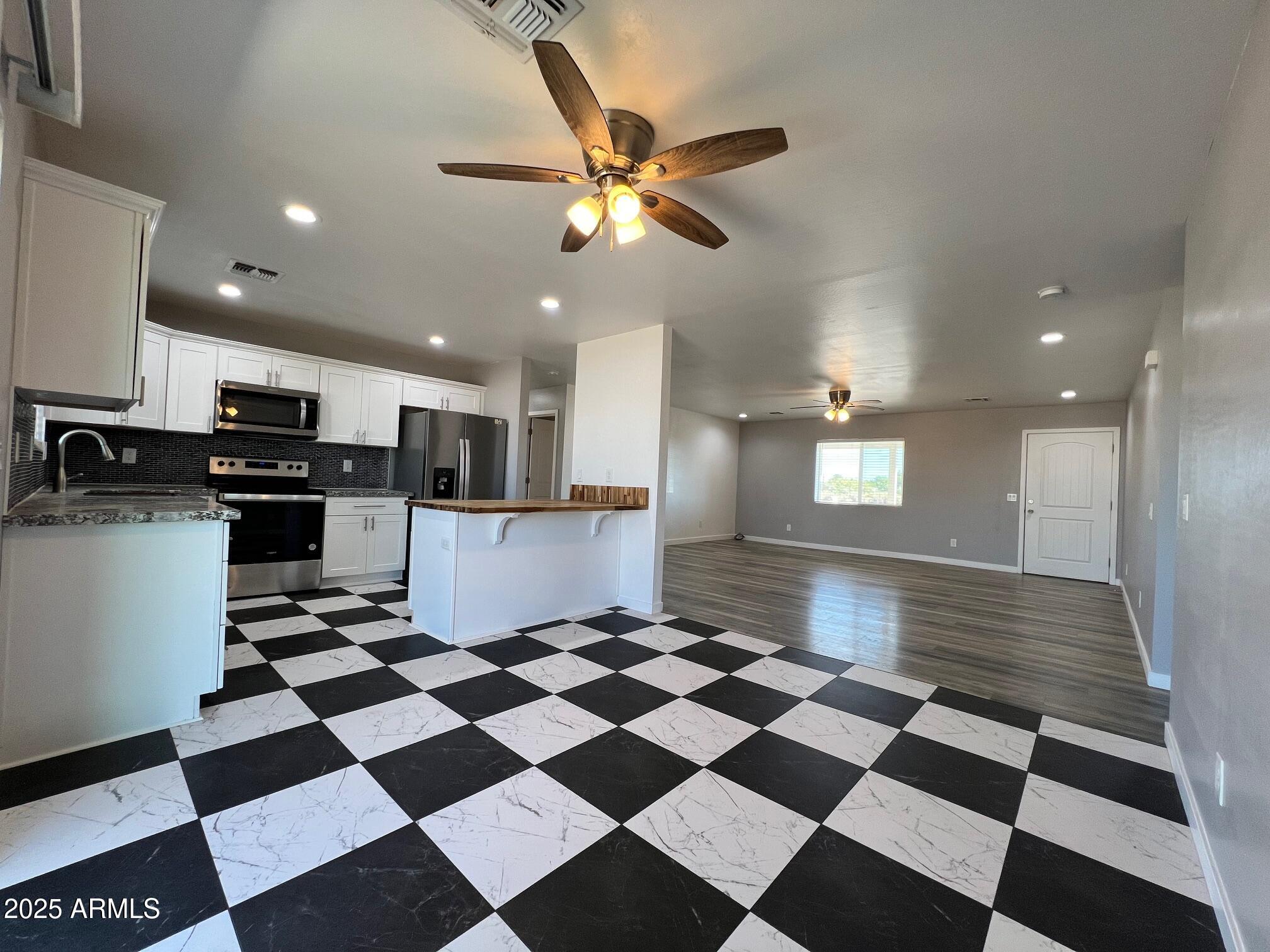 4552 North Loring Road Casa Grande, AZ 85194 - Photo 12 of 48 a kitchen with stainless steel appliances and cabinets