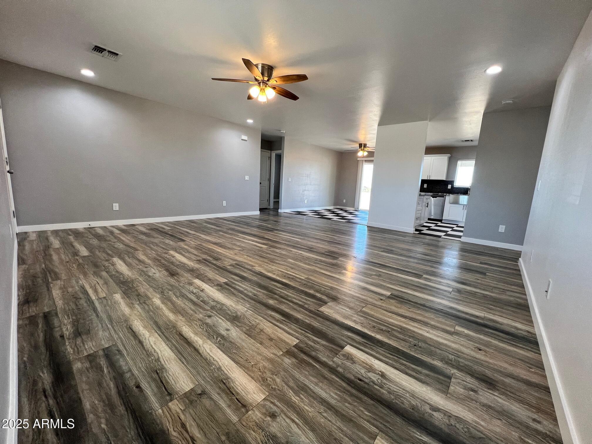 4552 North Loring Road Casa Grande, AZ 85194 - Photo 3 of 48 a view of an empty room with wooden floor and a ceiling fan