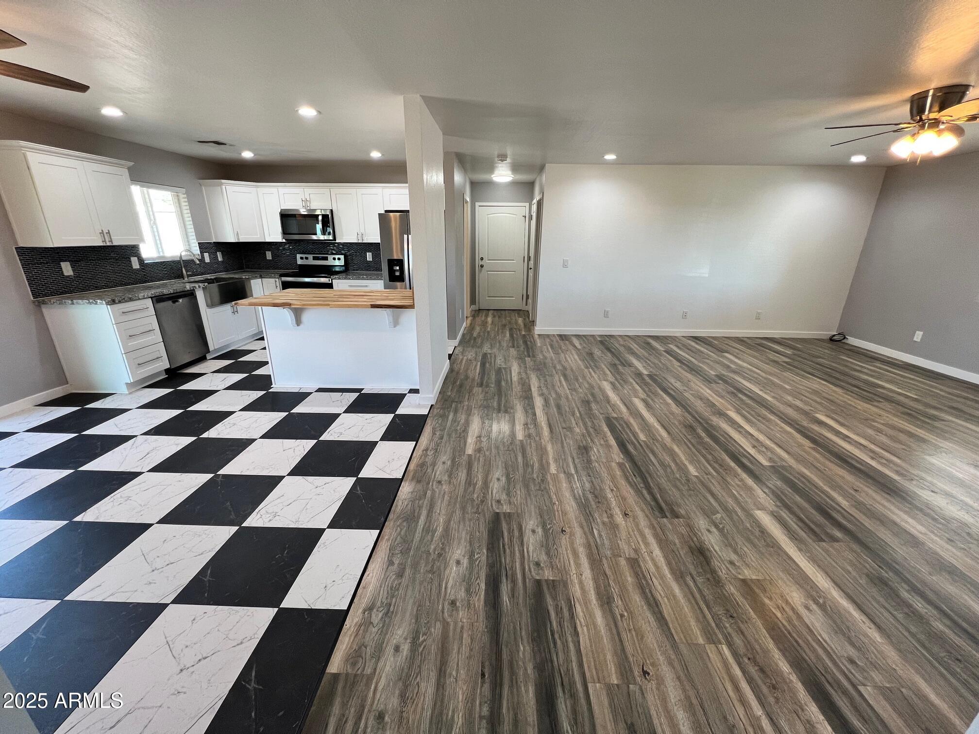 4552 North Loring Road Casa Grande, AZ 85194 - Photo 4 of 48 a kitchen with stainless steel appliances granite countertop a refrigerator and a black cabinets