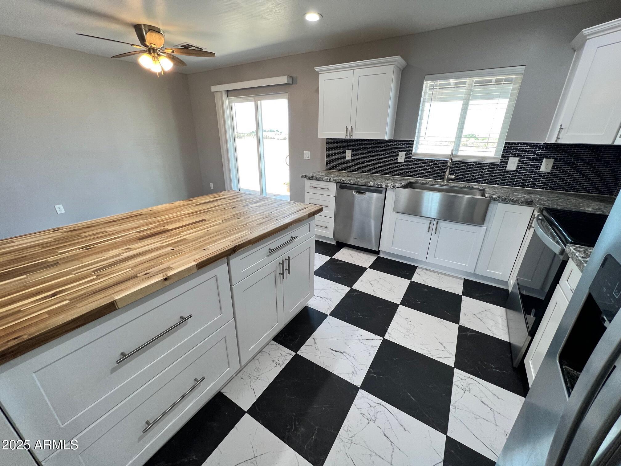 4552 North Loring Road Casa Grande, AZ 85194 - Photo 9 of 48 a kitchen with a checkered floor and white cabinets