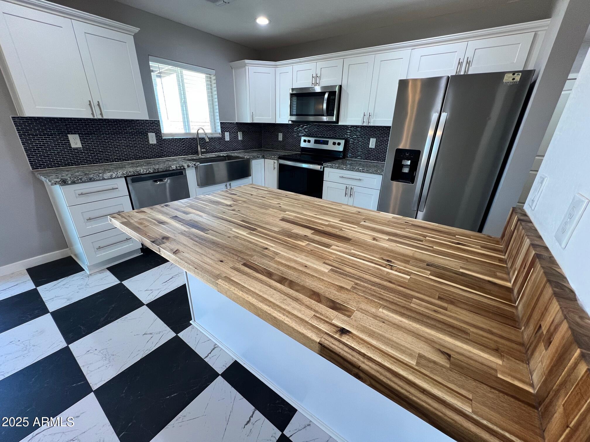 4552 North Loring Road Casa Grande, AZ 85194 - Photo 10 of 48 a kitchen with stainless steel appliances kitchen island granite countertop a refrigerator and a sink