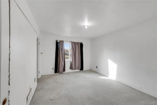 an empty room with windows and closet