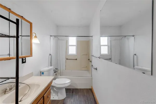 a bathroom with a granite countertop sink mirror vanity and toilet