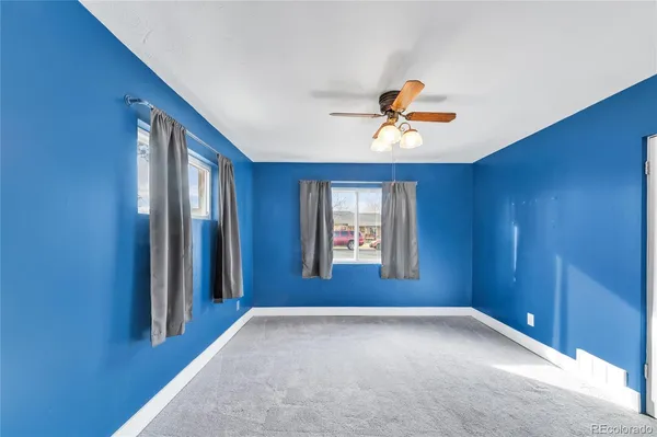 a view of a room with a ceiling fan and a window