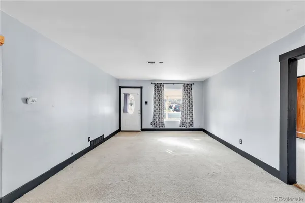 an empty room with closet and windows